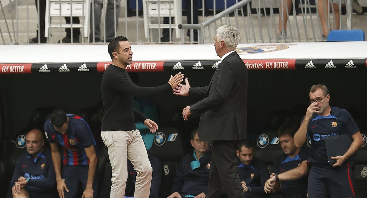 Xavi y Ancelotti se saludan antes del Clásico del Bernabéu.