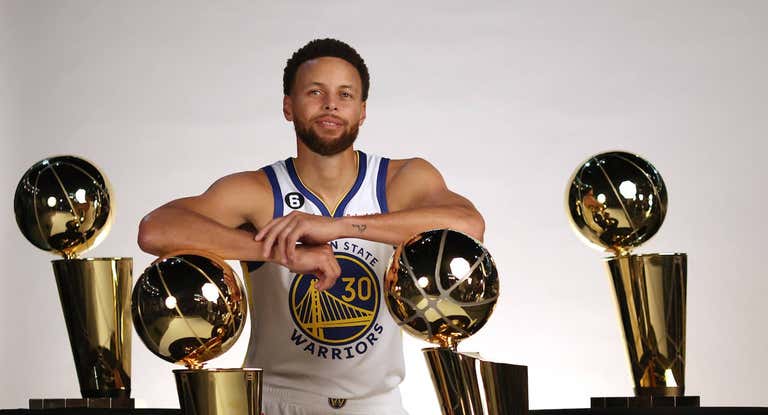 Stephen Curry posa con los cuatro trofeos de campeón de la NBA que tiene en su palmarés.
