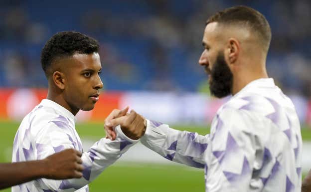 Benzema choca la mano con Rodrygo.  GETTY