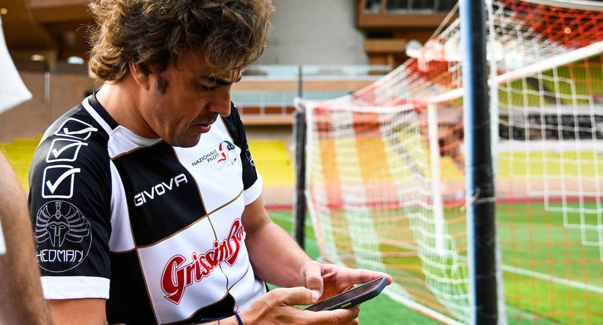 Fernando Alonso consulta el móvil durante un partido de fútbol benéfico en 2022. /Getty Images