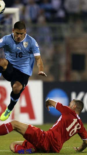 Thaer, en el suelo, en un lance con Maxi Pereira en la repesca para el Mundial de 2014.
