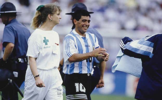 Maradona de la mano de la enfermera en el Mundial de Estados Unidos.  GETTY IMAGES