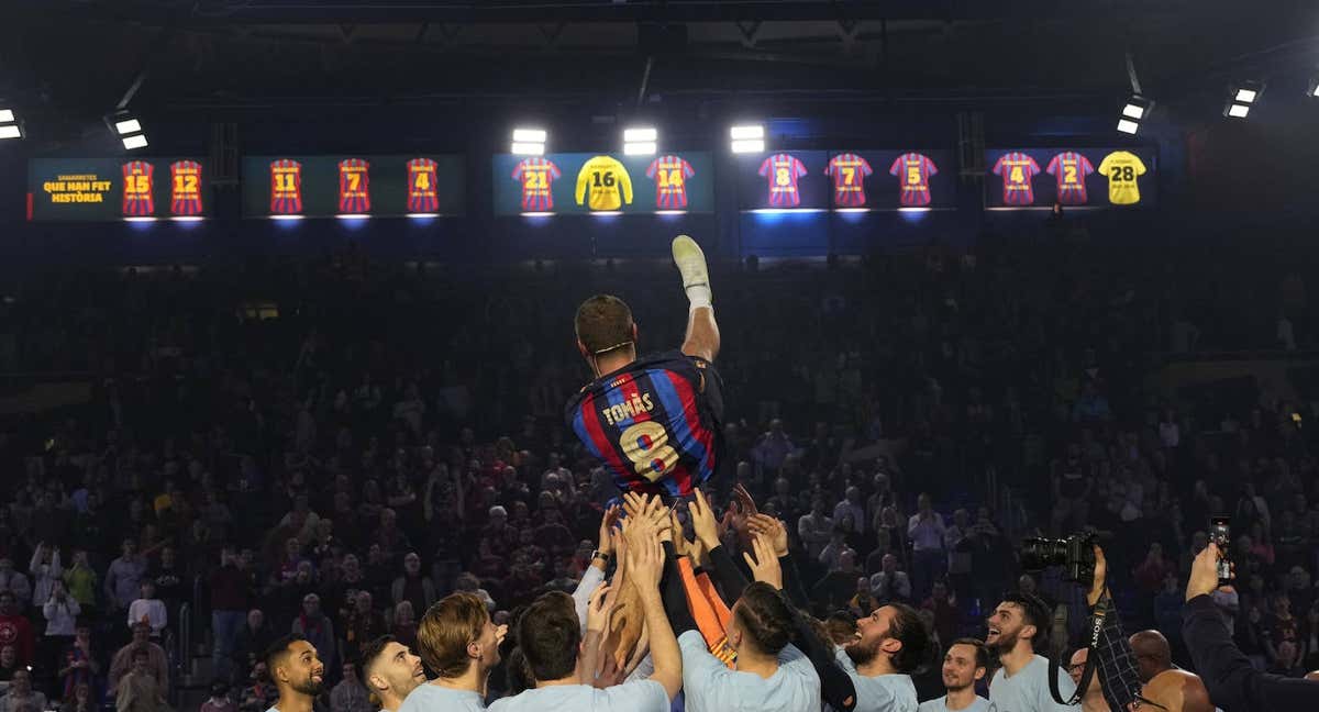 Jugadores y exjugadores del Barça mantean a Víctor Tomàs. /ALEJANDRO GARCÍA/EFE