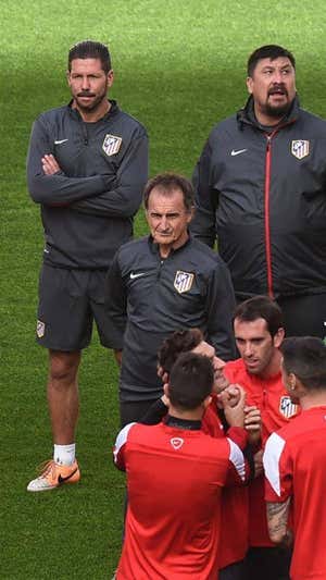 Simeone, 'Mono' Burgos y el 'Profe' Ortega, delante de varios jugadores rojiblancos en 2014.  EFE