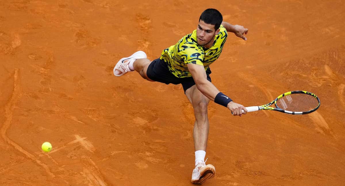 Carlos Alcaraz trata de llegar a una pelota durante su debut en el Conde de Godó. /EFE/Enric Fontcuberta
