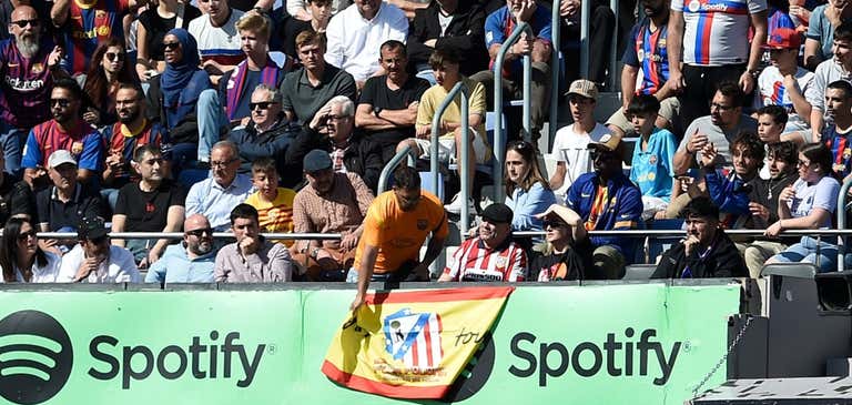 Aficionado del Barça retirando la bandera del Atlético de Madrid. ﻿