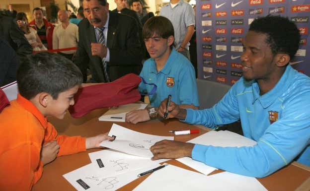 Víctor Sánchez y Samuel Eto'o firmando autógrafos. AGENCIAS