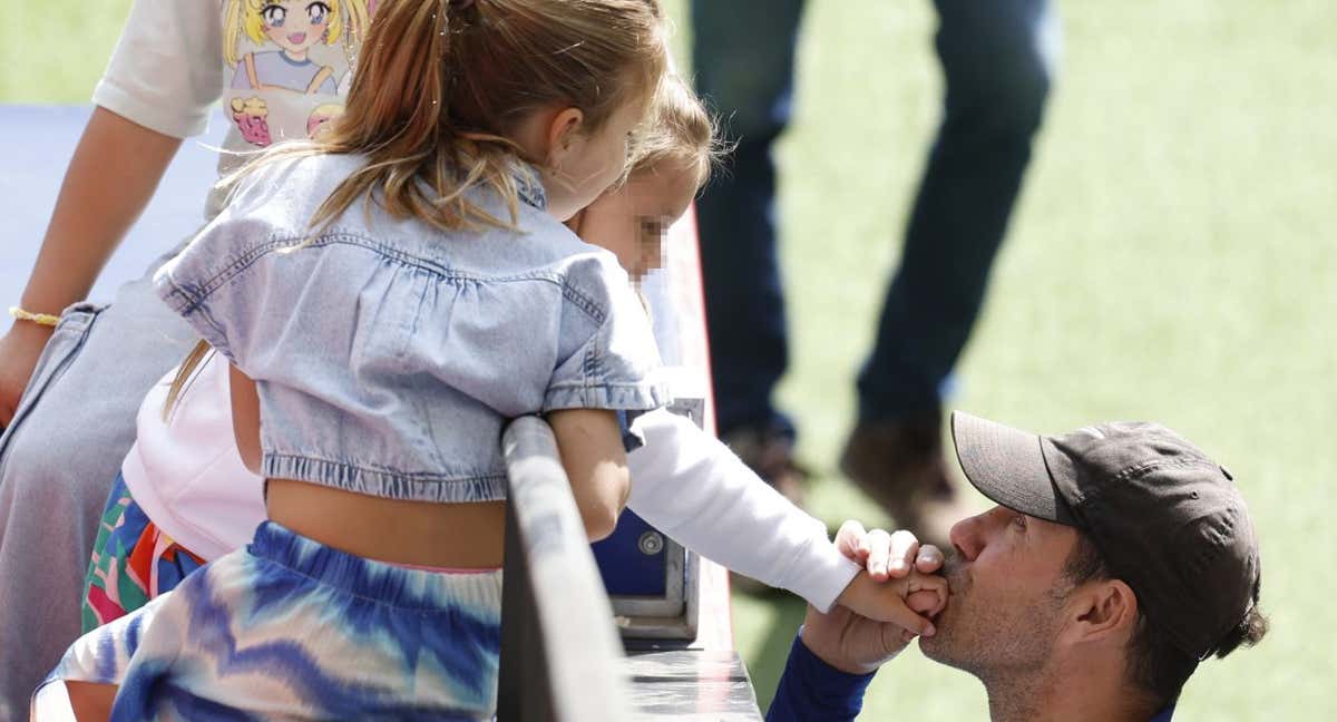 Simeone besa a una de sus hijas en el entrenamiento a puerta abierta que celebró el Atlético de Madrid el sábado 20 de mayo. /EFE