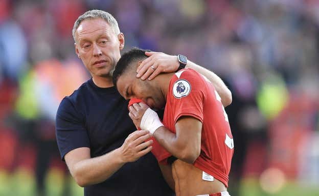 Steve Cooper, técnico del Nottingham, consoló a Renan Lodi tras el triunfo en casa ante el Arsenal (1-0). AFP