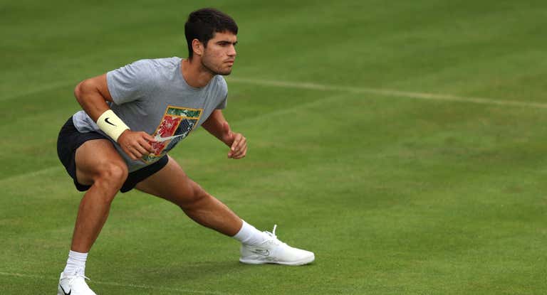 Carlos Alcaraz calienta antes de su primer entrenamiento en hierba en el torneo de Queen's.