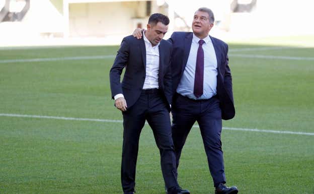 Xavi, junto a Joan Laporta. EFE