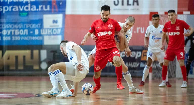 Artem Niyazov controla un balón en un partido entre el Partido Comunista y el Gazprom Ugra ante la mirada de su compañero Yanar Asadov.