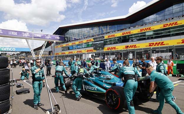 El equipo mueve el coche de Fernando Alonso en la parrilla del GP de Gran Bretaña de F1.  Aston Martin
