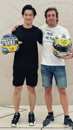 Guanyu Zhou y Fernando Alonso intercambian sus cascos en 2021.  G. Z.