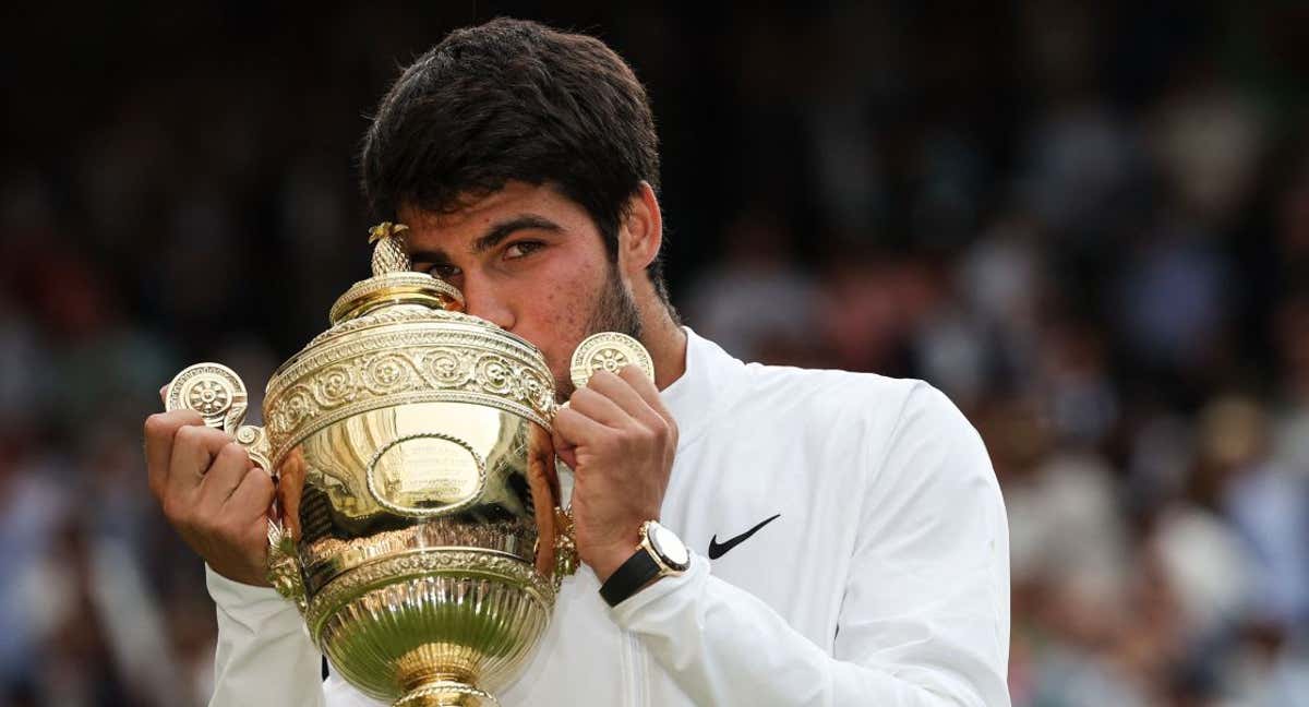 arlos Alcaraz besa la copa de Wimbledon tras vencer a Djokovic en la final. /Adrian DENNIS / AFP