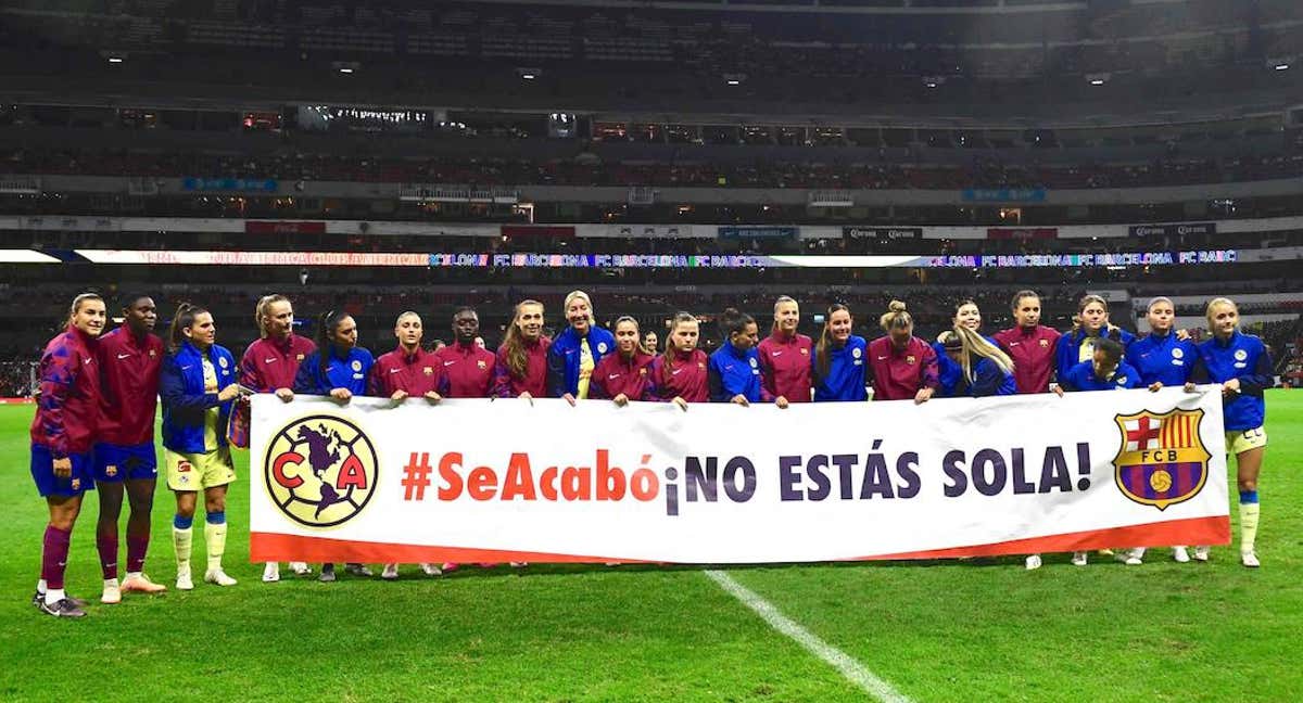 Jugadoras de Barça y América posan con una pancarta en favor de Jenni Hermoso. /AFP