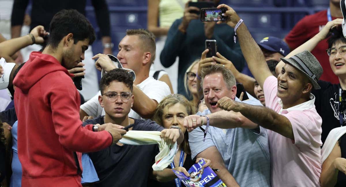 Carlos Alcaraz firma unos autógrafos en la pista central del US Open. /CLIVE BRUNSKILL / GETTY IMAGES