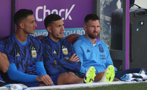 Messi en el banquillo junto a Paredes.  AFP