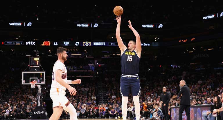 Nikola Jokic lanza a canasta ante Jusuf Nurkic de los Phoenix Suns.