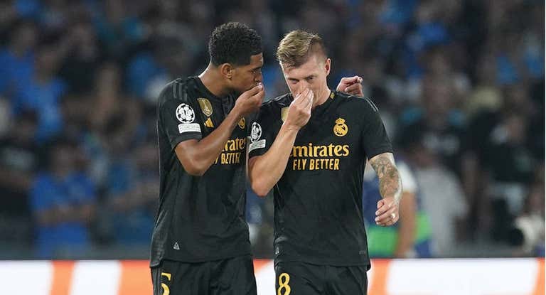 Jude Bellingham y Toni Kroos hablan durante un partido.