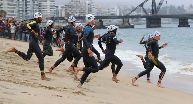 Atletas compitiendo en la prueba de natación en triatlón relevos mixtos.