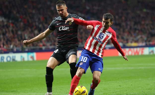 Valjent presiona el balón a Correa.  REUTERS