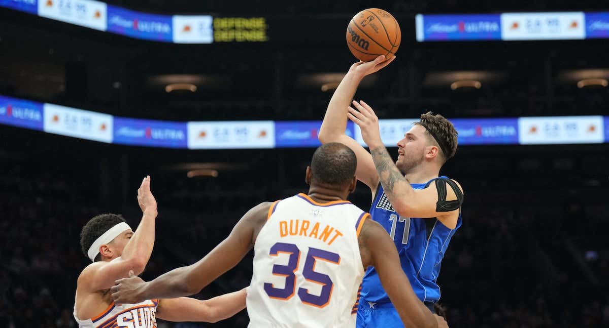 Luka Doncic lanza a canasta frente a la defensa de Devin Booker. /REUTERS