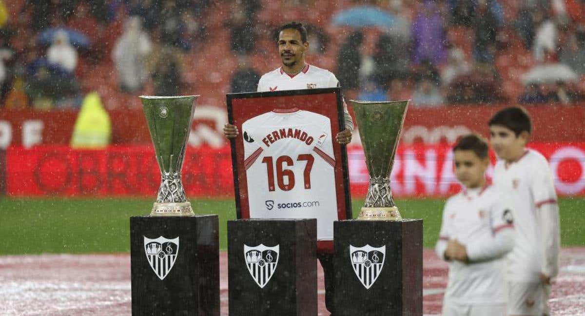 Fernando posa con los dos trofeos de Europa League y con la camiseta con el número de partidos disputados como sevillista. /LALIGA