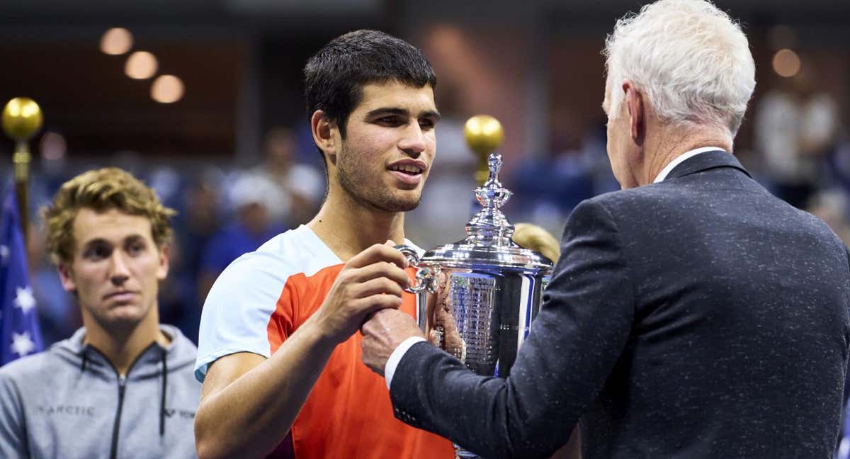 John McEnroe le entrega a Carlos Alcaraz el trofeo de ganador del US Open 2022.
