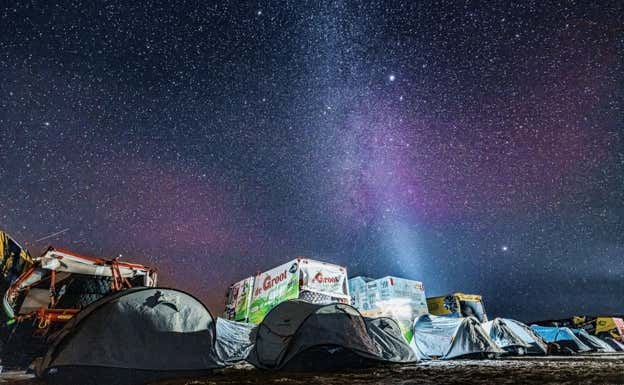 Camiones y tiendas de campaña bajo el cielo estrellado del Empty Quarter.  ASO