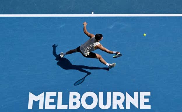 Carlos Alcaraz se estira a por una pelota en el Open de Australia.  EFE
