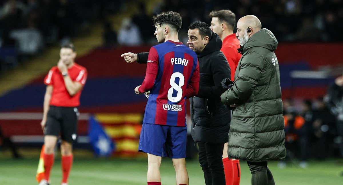 Pedri y Xavi conversan durante un partido. /AFP