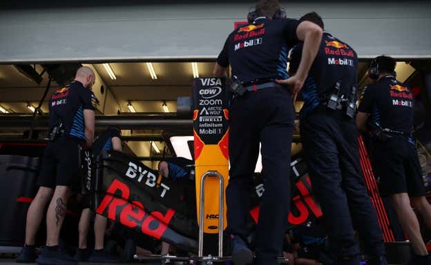 Los mecánicos de Red Bull forman una barrera durante las reparaciones en el RB20 de Sergio Pérez.  EP