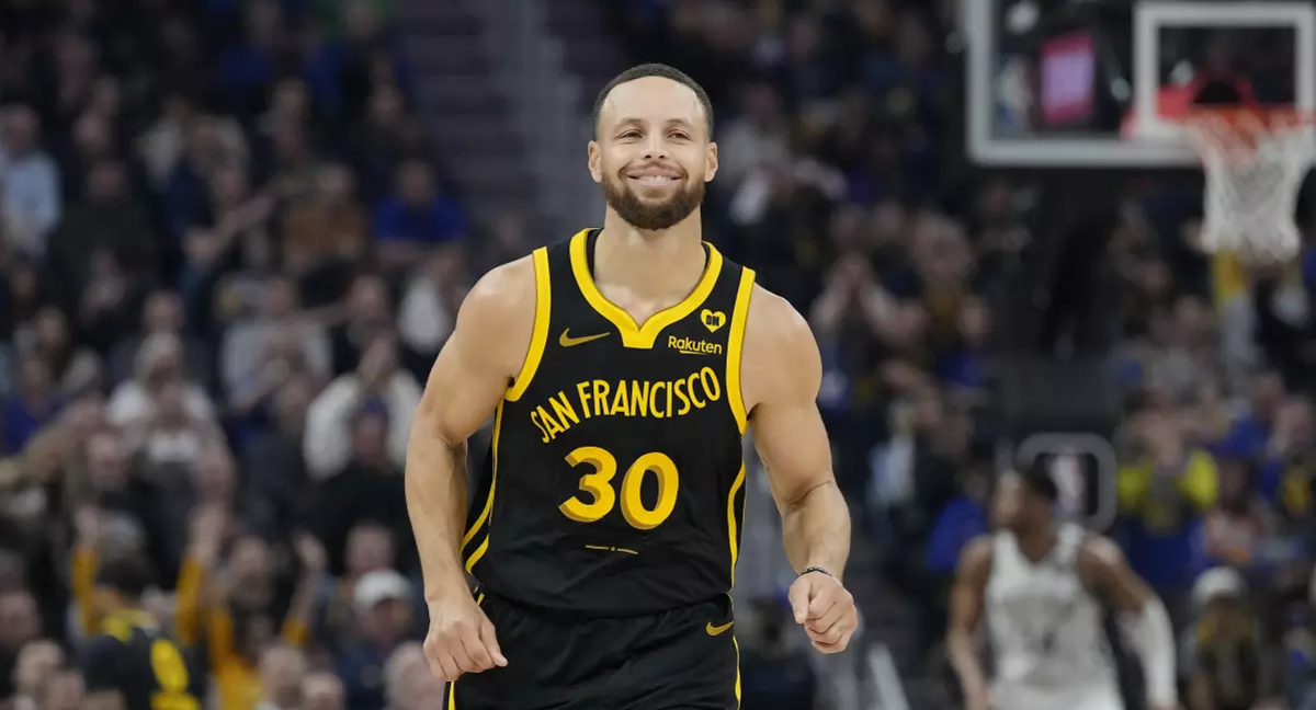Stephen Curry sonríe tras anotar un triple frente a los Milwaukee Bucks
