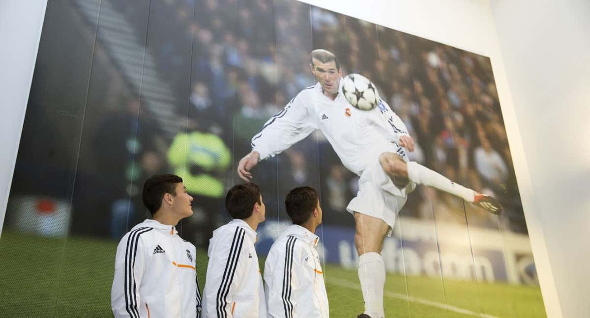 Tres canteranos del Madrid miran la foto del gol de Zidane que valió la Novena./REALMADRID.COM