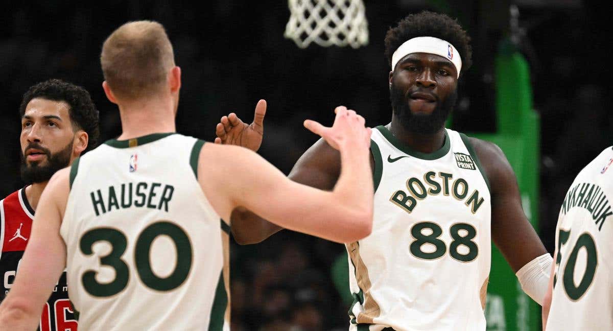 Neemias Queta saluda a Sam Hauser durante un partido de los Boston Celtics.