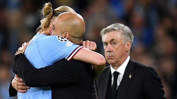 Ancelotti mira atento el abrazo entre Guardiola y Haaland en la ida de cuartos de final de la Champions League en el Santiago Bernabéu/AFP
