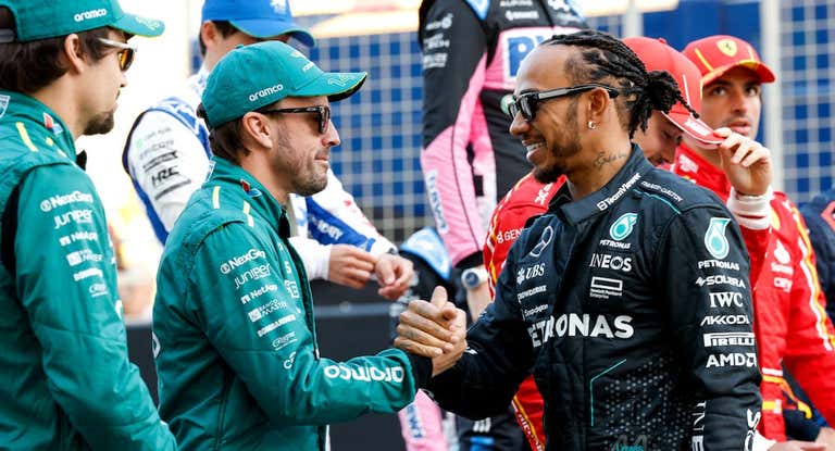 Fernando Alonso y Lewis Hamilton, saludándose.