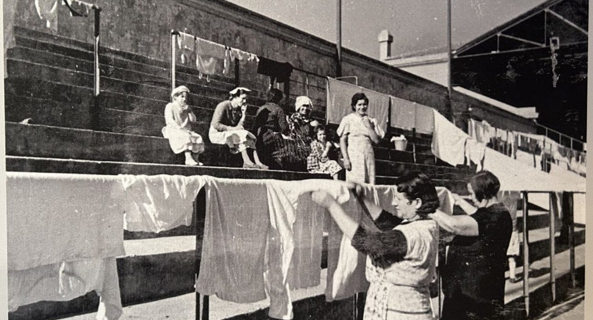 Unas mujeres tienden la ropa en el estadio de Montjuïc.