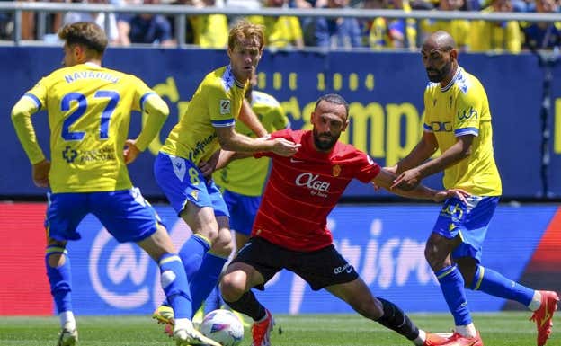 Muriqi pelea contra tres jugadores del Cádiz.  EFE