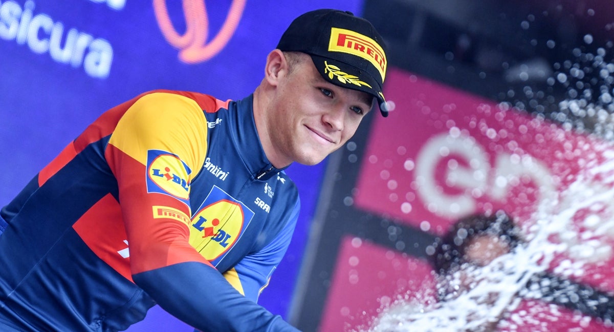 El italiano Jonathan Milan celebra en el podio del Giro.