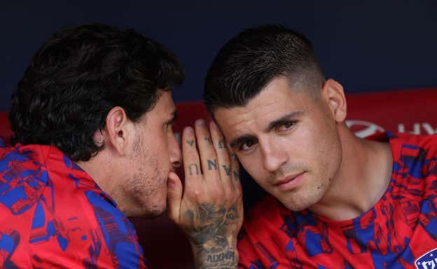 Morata escucha atentamente a Giménez en el banquillo.  REUTERS
