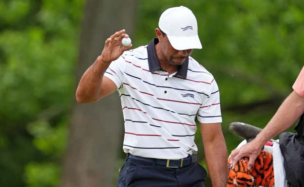 Tiger Woods recoge una bola tras fallar un putt. USA Today Sports
