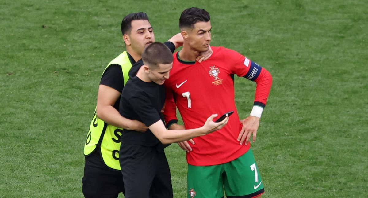 Cristiano, molesto, cuando uno de los cuatro espontáneos le agarran para hacerse una foto.