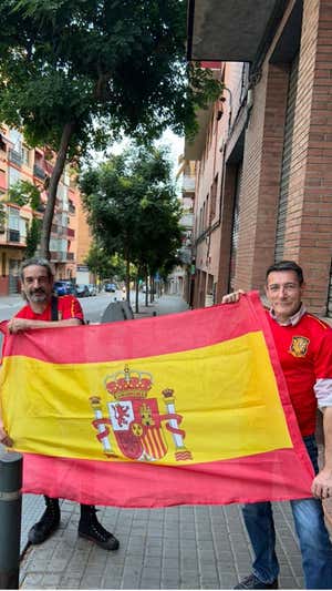 Dos hombres con la bandera de España celebran el triunfo. RELEVO