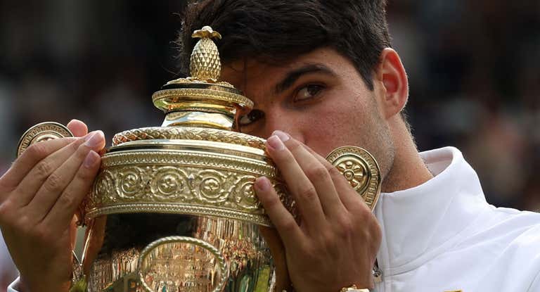 Carlos Alcaraz besa el trofeo de campeón.
