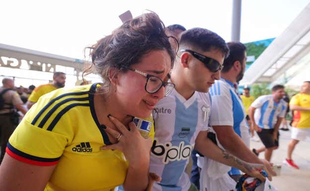 Dos aficionados sufren tras una avalancha.  REUTERS