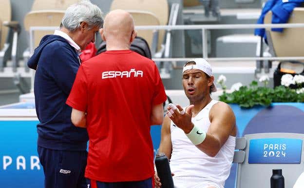 Rafa Nadal habla con su equipo sobre las molestias en la mano izquierda. REUTERS