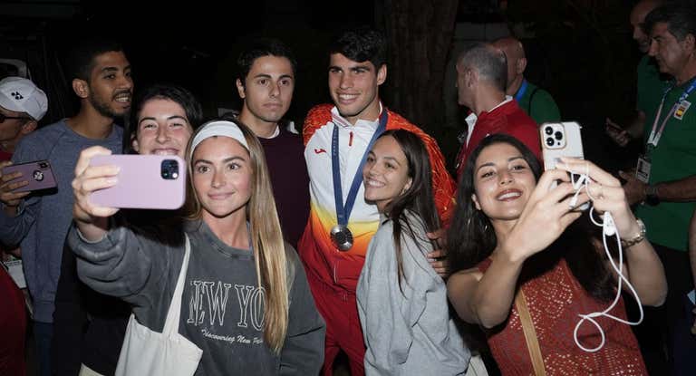 Carlos Alcaraz se fotografía con aficionados en la puerta de la Casa España tras colgarse la medalla de plata en París.