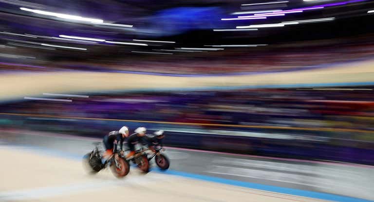 El equipo británico de velocidad cruza el velódromo a toda velocidad.